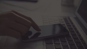 image of keyboard and person on phone